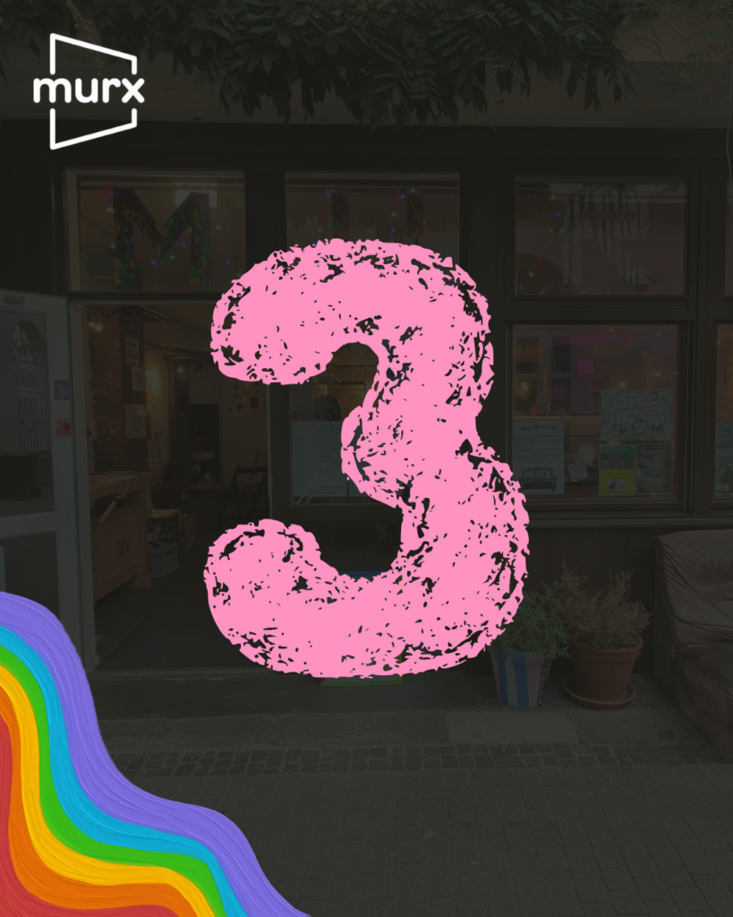 Bild in dessen Hintergrund ein etwas abgeblendetes Bild des Murx von Außen ist. | Links oben das Murx-Logo, Links unten ein Regenbogen in Pastellfarben, in der Mitte eine große 3 die wie mit Kreide geschrieben aussieht.